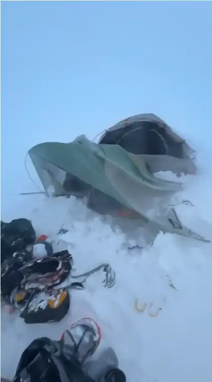 Tent and climbing gear in snowy mountain conditions