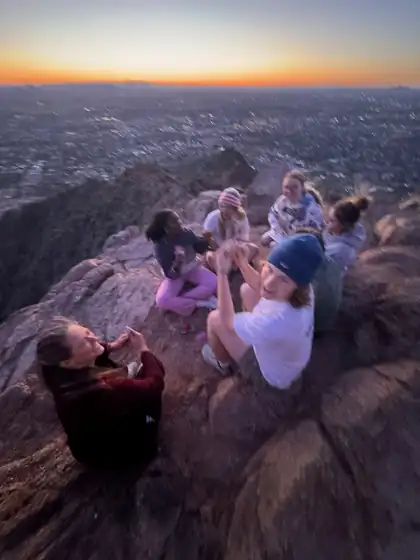 MCA members gathered on a rocky overlook at sunset