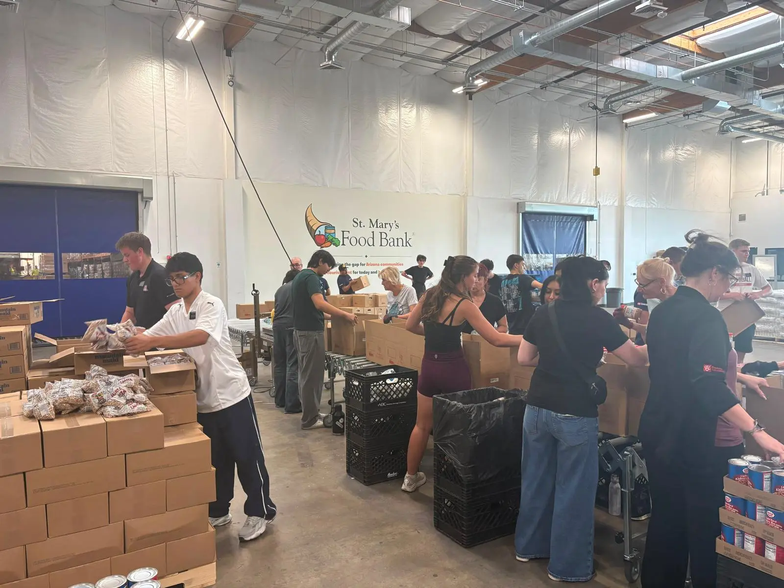 Volunteers packing food boxes together at St. Mary’s Food Bank