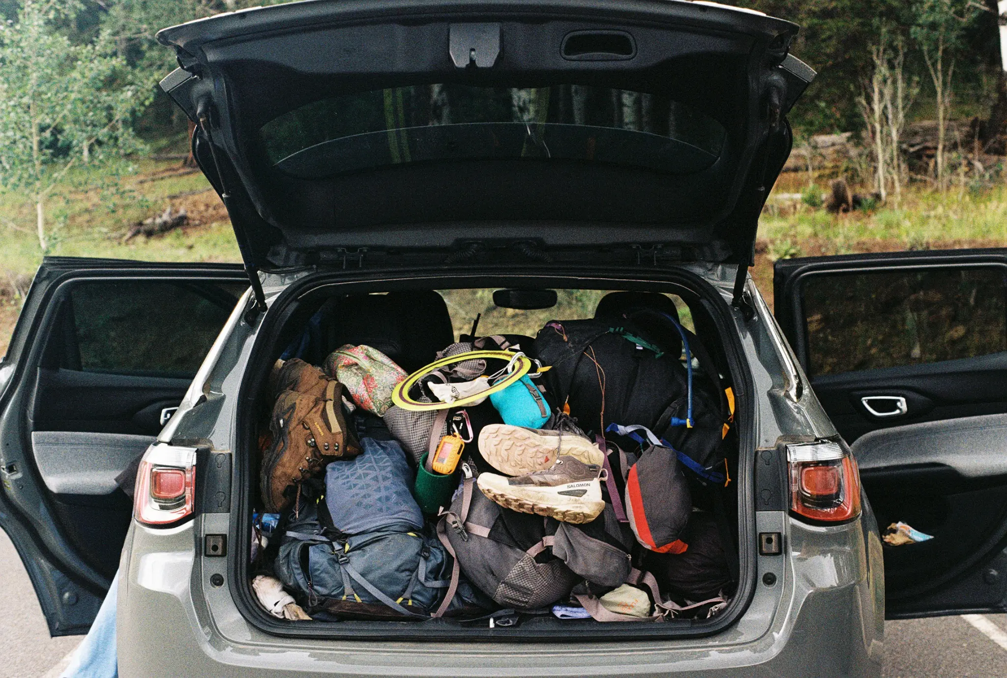 An open car trunk packed with outdoor gear